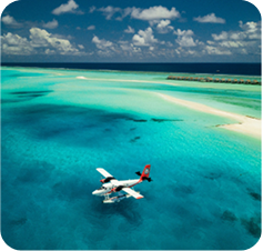 Seaplane flying above a tropical island lagoon